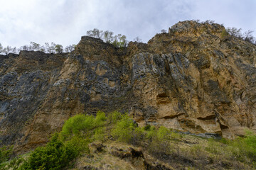 Fototapeta premium Rocky Cliff Face Under Cloudy Sky. Dagestan Russia.
