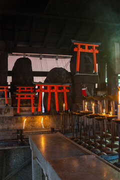 Traditional Shinto Altar with Miniature Torii Gates and Lit Candles