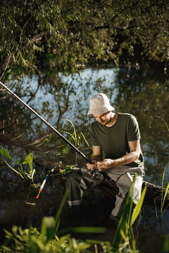Young fisherman with fishing rod near the lake at summer
