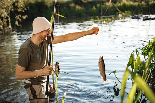 Young fisherman with fishing rod near the lake at summer