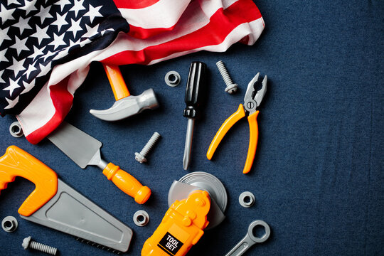 USA Labor Day concept with toy construction tools on blue background