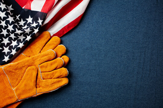 Labor Day concept with American flag and work gloves on denim background.