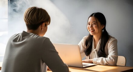 Obraz premium Smiling asian business woman interviewing candidate in bright office