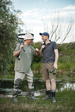 Two fishermen with fishing rods are going fishing near the lake