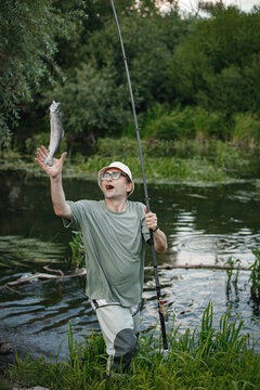 Fisherman with fishing rod near the lake at summer