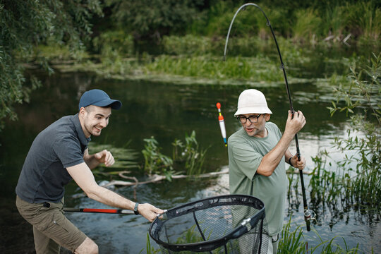 Two fishermen with fishing rods are going fishing near the lake