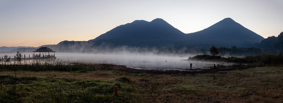 Atitlan lake with fog or mist at sunset with volcanos toliman and atitlan in the background. Tranquility and idyllic atmosphere perfect for relaxation