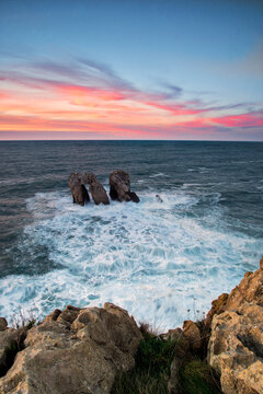Urro del Manzano rock formation in Liencres at sunset with long exposure silk effect on the ocean
