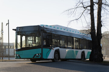 Fototapeta premium Sustainable urban transit solution in Estonia with a new electric bus parked on asphalt near a city plaza during a bright morning showcasing modern mobility trends