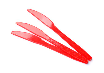 Naklejka premium Three red plastic knives isolated on white, top view