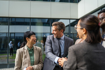 Obraz premium Diverse business professionals shaking hands at formal meeting