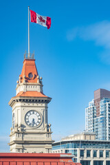 Obraz premium Victoria City Hall Clock Tower and Canadian Flag