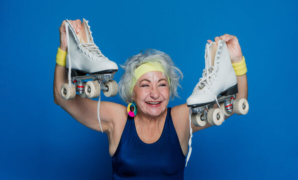 senior hispanic woman on roller skates and wearing sportswear from 70s retro disco style, mature gray haired female skater portrait 
