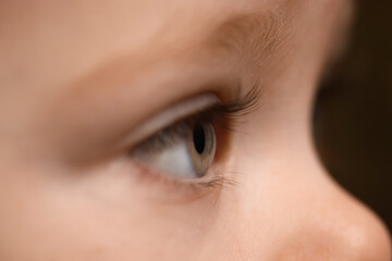 Naklejka premium Cute child with beautiful eyes on brown background, closeup