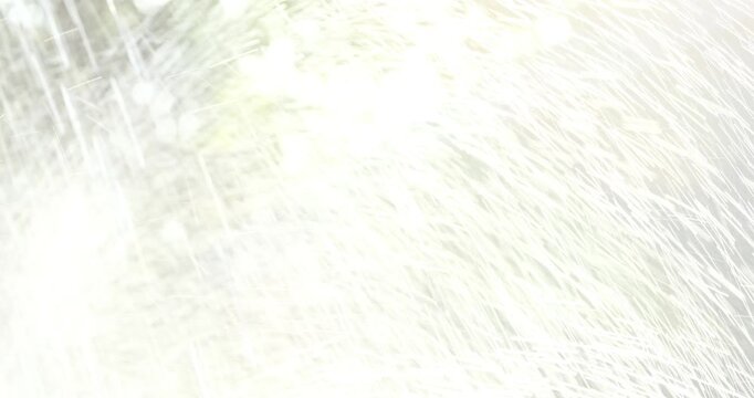 Close-up shot of heavy water pouring over a dark stone statue on a textured wall, with the camera tilting up to reveal a bright, intense spray of water.

