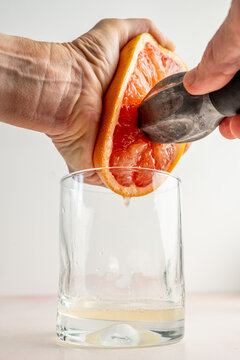 Half of a pink grapefruit being juiced 
