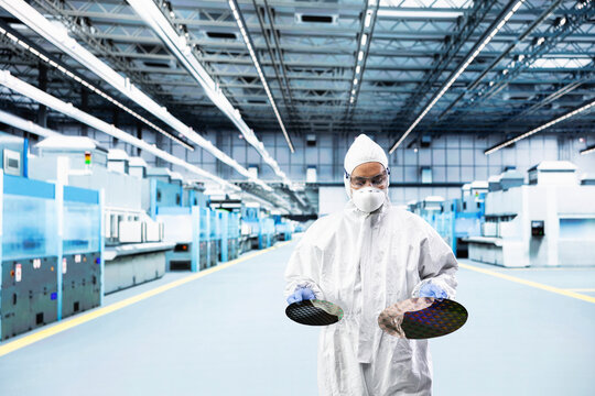 Indian man inspecting semiconductor production infrastructure, optimizing photolithography process. Scientist doing research and development on silicon wafers, trialing advanced materials
