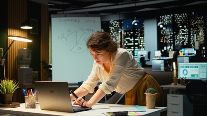 Manager fact checking before drafting financial projections on a white board, doing risk assessment and forecasting visual data. Planning a strategic project for development. Camera A.