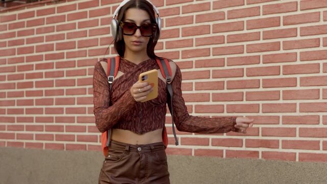 Happy young woman dancing while listening to music outdoors