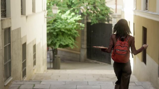 Happy university student dancing down the street
