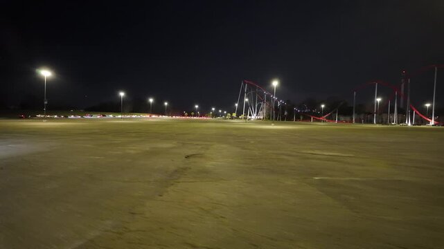 Driving by a Rollercoaster Amusement Theme Park at Night