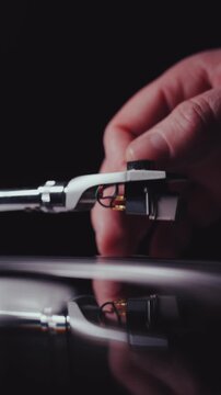 Vinyl turntable needle being placed onto a record vertical portrait video