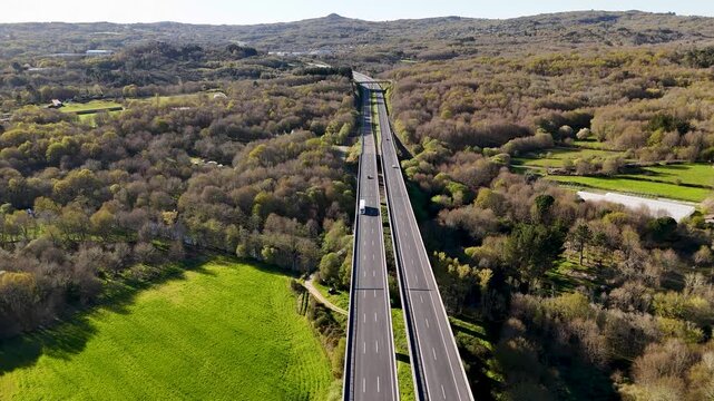 Aerial view of a highway traversing a dense forest