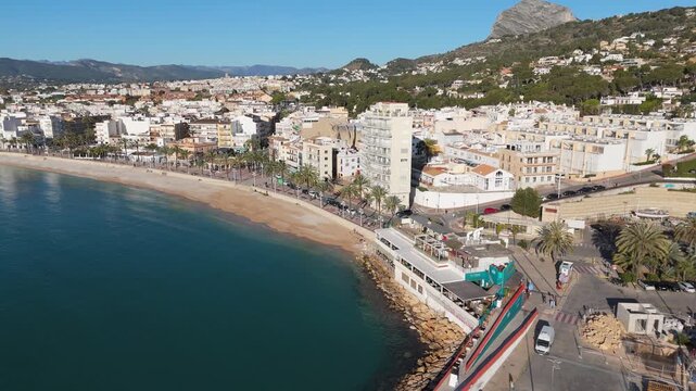 Drone flying along the sandy beach and coast of javea, alicante, spain