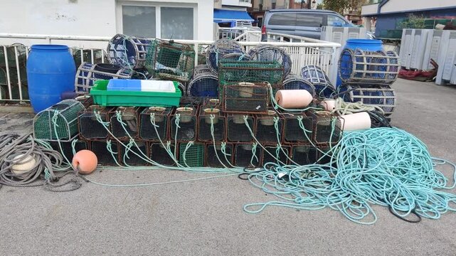 Fishing traps and ropes stacked on harbor dock