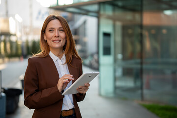 Confident businesswoman using digital tablet in city