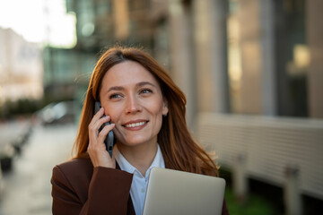 Successful businesswoman smiling talking on smartphone outdoors