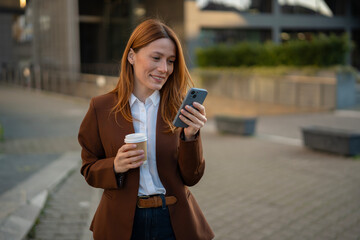 Young woman smiling while checking smartphone and coffee
