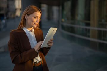 Businesswoman using digital tablet in urban setting