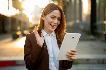 Happy businesswoman waving during video call on digital tablet