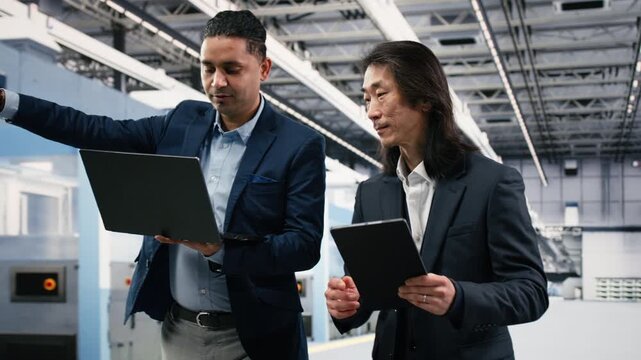 Overseeing automated systems, semiconductor factory and multiethnic managers working together. Inspecting hardware, brainstorming and management executives in microchip industrial plant, camera B