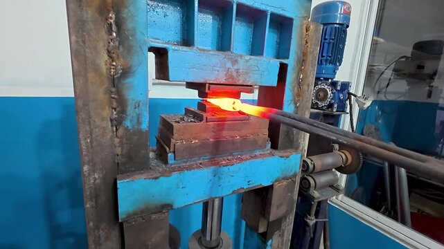 POV of an artisan blacksmith using a hydraulic press to shape incandescent damascus steel.