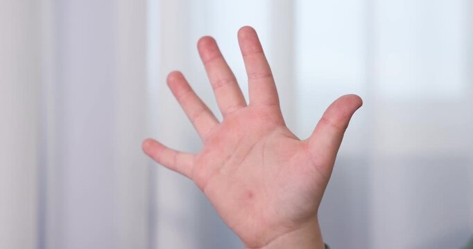Child counting on fingers at home, closeup