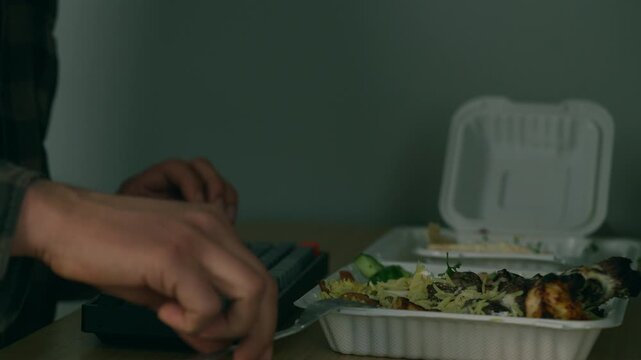 Eating takeaway at a desk while typing - work from home