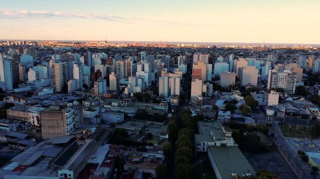 High altitude aerial drone view of a dense city skyline with skyscrapers and residential buildings at midday.