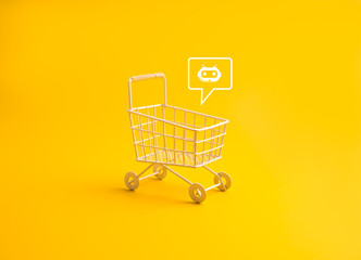 Minimal shopping cart with chatbot icon on yellow background. AI assistant for online shopping, ecommerce automation, digital retail technology, smart customer service and modern shopping experience. © tete_escape