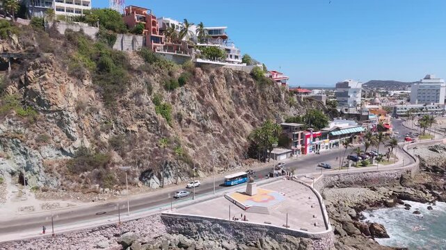 Vista a&eacute;rea con dron de la playa urbana en el Pac&iacute;fico, con una vista costera donde las olas del mar rompen contra las rocas en un d&iacute;a soleado.