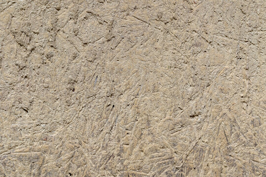 Rough textured surface of a traditional wall made from natural clay and dried organic plant straw