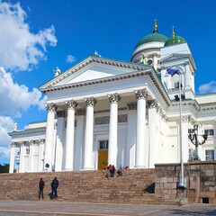 Obraz premium A large white building with columns and a green dome under a blue sky