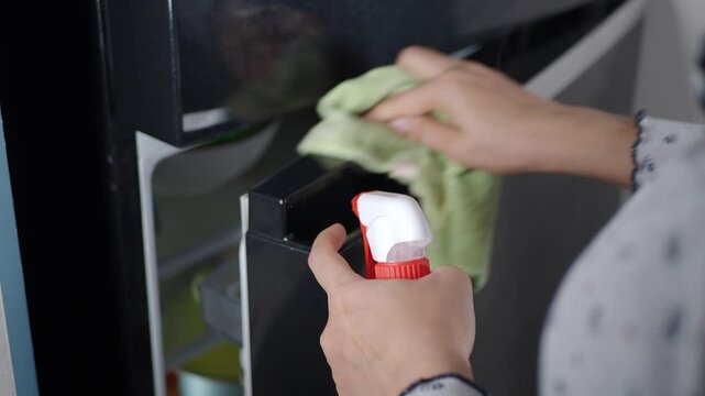 Cleaning the kitchen with a cloth and spray