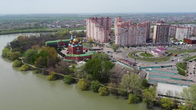 Aerial view of the Russian Orthodox Church of the Nativity of Christ on the banks of the Kuban River and the panorama of the Yubileiny district in Krasnodar