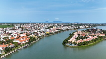 Fototapeta premium Hoi An (Hoian), Da Nang City (Quang Nam), Vietnam: 4K aerial view of ancient town, UNESCO heritage, Hoai river, boats, lantern streets and historic waterfront.