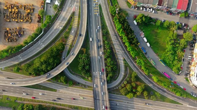 Top Down Aerial View of Urban Highway Interchange with Traffic Flow. Urban expressway infrastructure with curved flyovers and road junctions representing transportation networks and mobility.