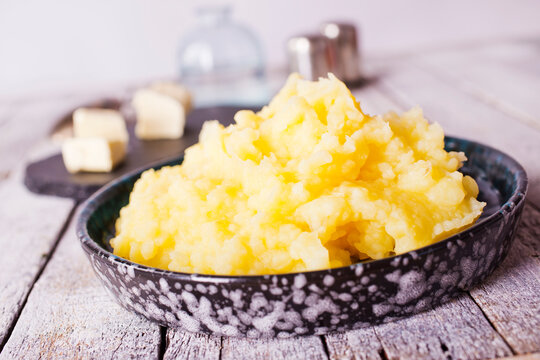 Mashed potatoes in bowl on a wooden background