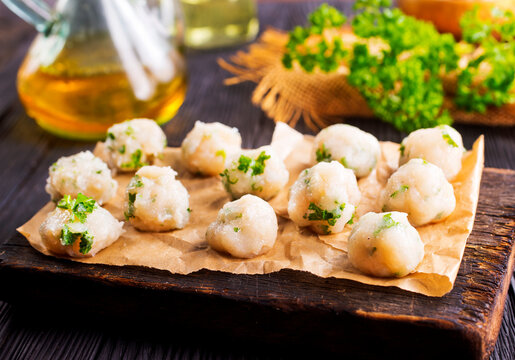 raw chicken balls on wooden board