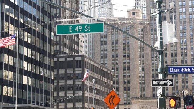New York Park Avenue, 49 street sign in Manhattan Midtown, United States. Urban road sign in american city, traffic sign in NYC, USA. Building architecture near Grand Central. American flag.